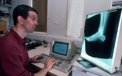 A man standing in front of a computer.