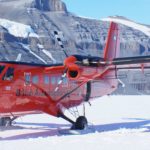 A airplane that is on top of a snow covered mountain.