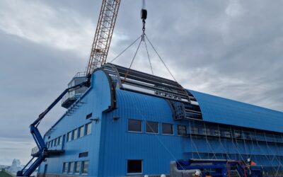 A large crane on the back of a large blue building