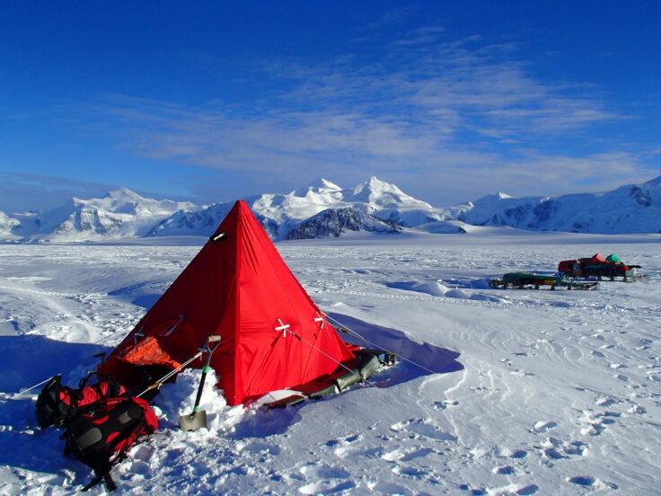 A group of people standing on top of a snow covered mountain