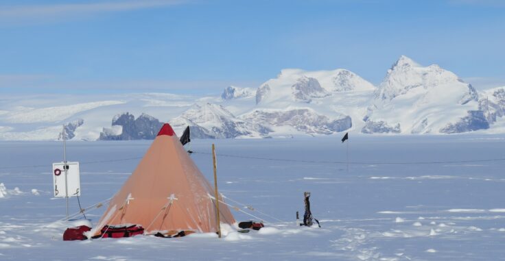 A group of people standing on top of a snow covered mountain