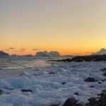 A snow covered landscape at sunset