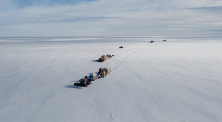 A group of people riding skis down a snow covered slope